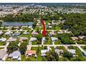 Overhead shot of neighborhood, showcasing lush greenery and pond at 1785 Morning Dove Ln, Englewood, FL 34224