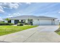 Well-maintained single-story home featuring a two-car garage, beautiful lawn, and tropical landscaping at 2106 Damascus Ln, Punta Gorda, FL 33983