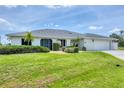 Well-maintained single-story home featuring a two-car garage, beautiful lawn, and tropical landscaping at 2106 Damascus Ln, Punta Gorda, FL 33983