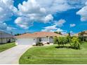 A charming home with a well-manicured lawn and garden, showcasing the property's curb appeal and inviting exterior at 25 Mariner Ln, Rotonda West, FL 33947