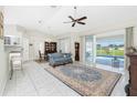 A spacious living room with tile floors, a ceiling fan, and access to the pool area through sliding glass doors at 25 Mariner Ln, Rotonda West, FL 33947