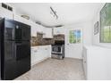 Functional kitchen with stainless steel appliances, white cabinets, and neutral backsplash at 348 W Wentworth St, Englewood, FL 34223