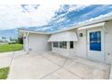 Exterior featuring a blue entry door with awning, concrete patio, and windows with hurricane awning at 39 Caddy Rd, Rotonda West, FL 33947
