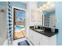 Bright bathroom with black granite counters, white cabinets, beach-themed decor, and access to the pool at 4221 Ulster Ave, North Port, FL 34287
