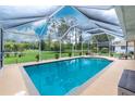 Beautiful pool with a screened enclosure and a view of the lush, green backyard at 4227 Winona St, Port Charlotte, FL 33948