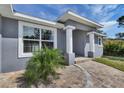 Close-up of a home's entrance featuring white pillars, brick walkway and well-maintained landscaping at 5781 Elton Rd, Venice, FL 34293