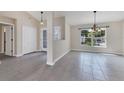 Bright living room with tile floors, modern light fixture, and large windows at 5781 Elton Rd, Venice, FL 34293