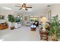Bright living room with tropical decor, ceiling fan, comfortable seating, and lots of natural light at 609 Deerwood Ave, Englewood, FL 34223