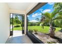 View from screened porch to the manicured lawn and tropical landscaping that surround the property at 7059 Quigley St, Englewood, FL 34224