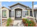 Close up of covered front door with decorative glass, attractive landscaping, and beautiful curb appeal at 7130 Scarlet Sage Ct, Punta Gorda, FL 33955