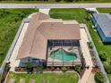 Aerial view of a fenced backyard with a screened-in pool, patio, and well-maintained landscaping at 7218 Darlington St, Englewood, FL 34224
