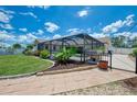 Backyard view featuring a screened-in pool, lush landscaping, and a paved patio for outdoor enjoyment at 7218 Darlington St, Englewood, FL 34224
