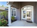 Welcoming front entrance with a well maintained garden, columns, an arched entryway and views into the house at 7376 Stetson Ln, Port Charlotte, FL 33981