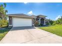 Home exterior view highlighting a large garage, concrete driveway, and a well-maintained lawn on a sunny day at 7376 Stetson Ln, Port Charlotte, FL 33981