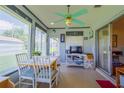 Bright sunroom featuring a dining area with white furniture and large windows overlooking the outdoor greenery at 7437 Bass St, Englewood, FL 34224