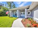A home's front porch features a walkway, flower garden, and seating at 7933 Minardi St, North Port, FL 34291