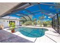 Screened-in private pool with clear blue water, brick patio and tropical plants, offering a relaxing outdoor oasis at 926 Boundary Blvd, Rotonda West, FL 33947