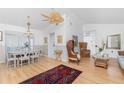 Bright living room with elegant furnishings, including wicker chairs, a ceiling fan and wood floors at 9457 Heartwellville Ave, Englewood, FL 34224