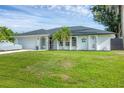 Beautiful single-story home featuring a well-maintained lawn, two-car garage, and architectural details at 10263 Waterford Ave, Englewood, FL 34224