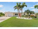 Charming home featuring a manicured lawn and tropical landscaping at 1030 Haste Ln, Englewood, FL 34223