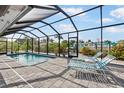 Screened-in pool area with patio furniture overlooking the canal at 1030 Haste Ln, Englewood, FL 34223