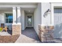 Inviting front entrance featuring stone accents, a modern light fixture, and a walkway at 14756 Ponce De Leon Trl, Port Charlotte, FL 33981