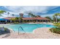 Relaxing community pool with ample seating, palm trees, and beautiful clubhouse at 1530 Hyssop Loop, North Port, FL 34289