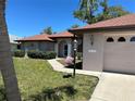 Exterior elevation featuring an arched entryway and beautiful landscaping at 18122 Windswept Ave, Port Charlotte, FL 33948