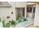 A well-kept front entrance features charming decor, plants, and a covered patio beyond sliding glass doors at 2004 Longpointe Cir # E2, Venice, FL 34293