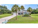 Inviting single-story home with a lush green lawn and mature palm trees at 2541 Northway Dr, Venice, FL 34292