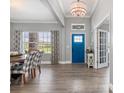 Bright foyer with a blue front door, wood-look floors, and elegant decor at 9151 Melody Cir, Port Charlotte, FL 33981