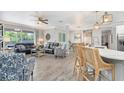 Open living room featuring wood-look floors, modern furnishings, and natural light at 9151 Melody Cir, Port Charlotte, FL 33981
