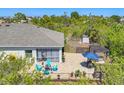 Aerial view of a backyard patio with outdoor seating and an umbrella, surrounded by privacy landscaping at 9213 Spring Cir, Port Charlotte, FL 33981