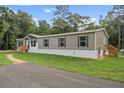 Single-wide manufactured home with gray and beige siding at 6144 La Pine Rd, Brooksville, FL 34602