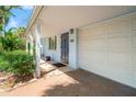 Charming covered front porch and garage, featuring a striking blue door, tiled surface, and lush plants at 8285 28Th N Ave, St Petersburg, FL 33710