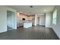 Open concept living space with gray tile floors, white kitchen, and access to other rooms at 9137 Gulf Haven Dr, Parrish, FL 34219