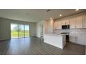 Modern kitchen with white cabinetry, a large island, and sliding glass doors leading to backyard at 9137 Gulf Haven Dr, Parrish, FL 34219
