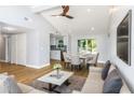 Open concept living and dining area with light wood floors and modern furnishings at 1004 Greenleaf Way, Tarpon Springs, FL 34689