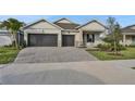 Two-story house with two-car garage, paver driveway, and landscaped front yard at 7474 Sea Manatee St, Parrish, FL 34219