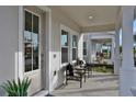 Inviting front porch with seating, offering a welcoming entrance to this stylish home at 168 Eagleston Ln, Lakewood Ranch, FL 34240
