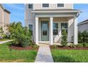 Inviting front porch with lush landscaping and a modern green front door at 9031 Duany Ln, Lakewood Ranch, FL 34240