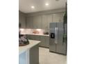 Modern kitchen with gray cabinets, stainless steel appliances, and quartz countertops at 9230 Gulf Haven Dr, Parrish, FL 34219