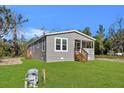 Gray single-story house with a wooden porch and green lawn at 12351 Lamont Ave, New Port Richey, FL 34654