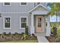 Inviting entryway with a charming pink front door and manicured landscaping at 180 Eagleston Ln, Lakewood Ranch, FL 34240