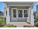 Close-up of front porch with white columns and a glass-paneled front door at 9019 Rothman Ln, Lakewood Ranch, FL 34240