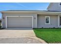 Spacious two car garage with a gray door and adjacent lawn at 9019 Rothman Ln, Lakewood Ranch, FL 34240