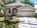 Single-story home with two car garage, arched entrance and a well-maintained lawn at 1652 Open Field Loop, Brandon, FL 33510