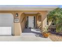 Covered front entryway with an arched doorway and stone accents next to the home's two-car garage at 909 Dawn St, Venice, FL 34285