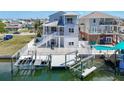 The beautiful back of the house, including a private boat lift and waterfront access on a sunny day at 13737 Victor Ave, Hudson, FL 34667