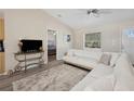 Cozy living room featuring a plush rug, white sectional, and a view into the bedroom at 33021 Ranch Rd, Dade City, FL 33523